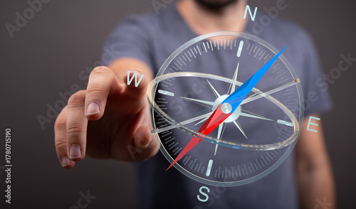 Bild auf Leinwand A person's hand touching a transparent compass, representing navigation, guidance, and direction