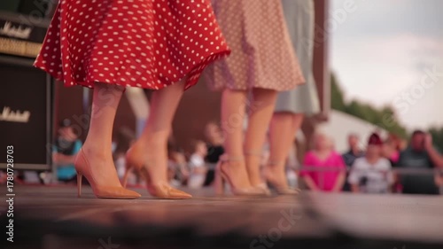 Dancers In Polka-Dot Skirts And High Heels Perform A Kick Line On Stage. Womens Legs In A Synchronized Dance At A Retro-Themed Event.