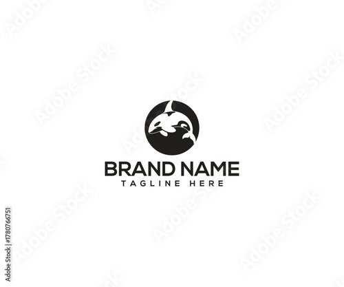 Orca Logo Design: A minimalist logo design featuring a silhouette of a majestic orca, gracefully breaching the surface, against a circular backdrop. The clean design emphasizes elegance.
