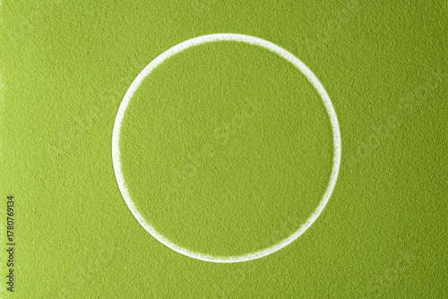 Bright green matcha powder surface with a clean white circle in the center creates a minimalist and modern abstract background.