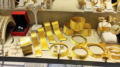 Beautiful women's jewelry gold bracelets with decorative patterns on the shop window.
