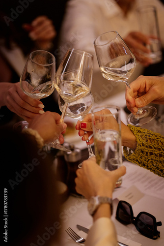 Hand with a glass of wine in the night atmosphere of the restaurant