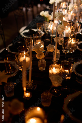 Luxurious setting of dark restaurant tables with candles and fresh flowers
