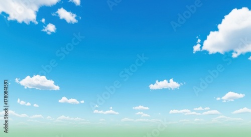 Fototapeta Naklejka Na Ścianę i Meble -  A serene blue sky with fluffy white clouds and a hint of green grass below.