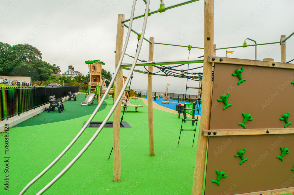 Fototapeta premium Empty childrens playground with wooden boat, slides and climbing frames