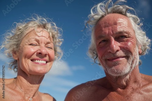 An elderly couple kissing and smiling at the sea