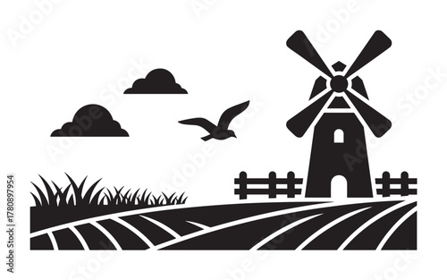 Black silhouette of a windmill with rotating blades, surrounded by fields, a fence, and a bird flying under two clouds in the sky.