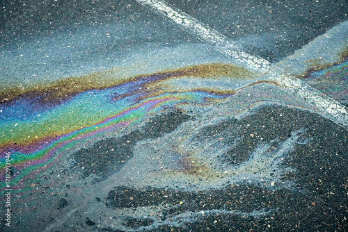 Tableau sur toile Bright oil spill forming mesmerizing rainbow hues on the wet asphalt after rain
