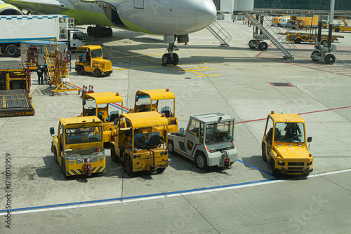 Multiple aircraft pushback tractors and ground support vehicles parked on the tarmac at an airport, ready for aircraft towing and ground operations.