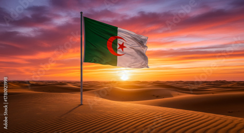 Fototapeta Naklejka Na Ścianę i Meble -  Algerian Flag in Desert Dunes at Sunset