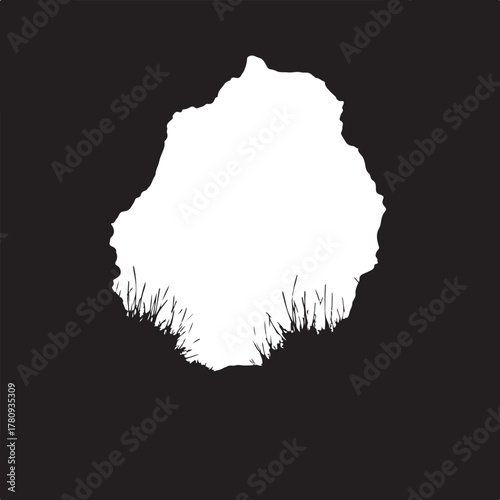 Black silhouette of jagged rock formation with grass