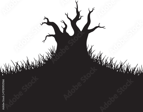 Black silhouette of gnarled bare tree on grassy hill