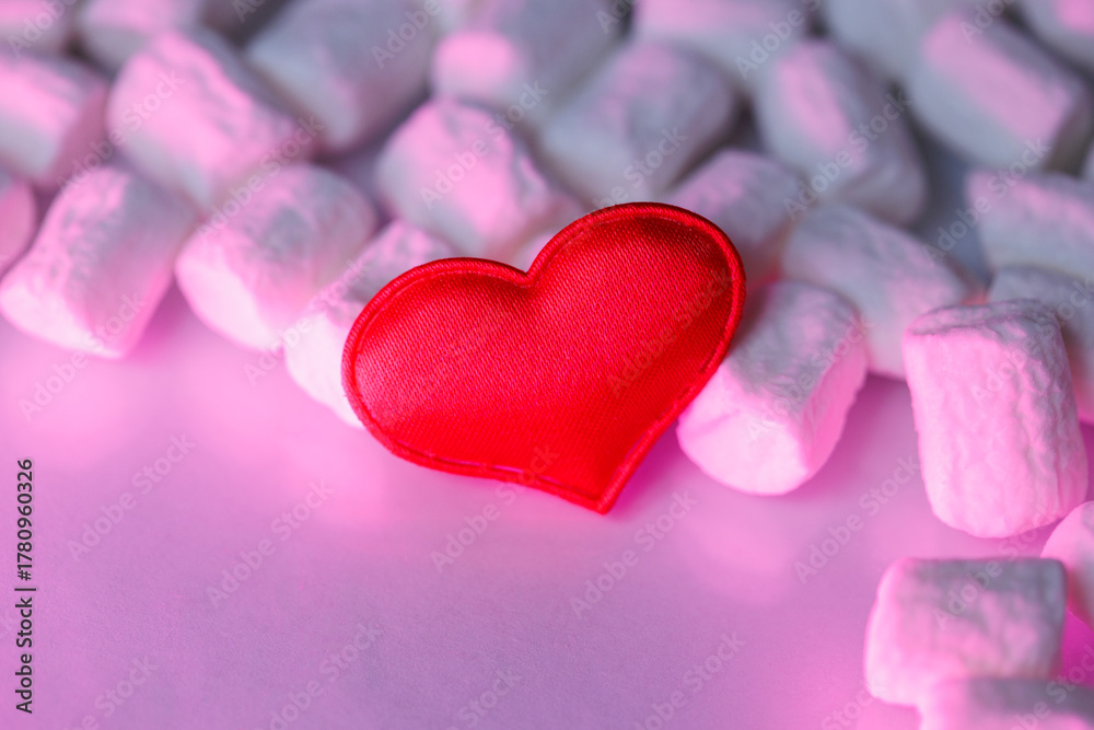 Obraz premium Red heart on a pink background with marshmallows. Romantic minimalist composition symbolizing love, tenderness, and sweetness. Perfect for Valentine’s Day, cards, or celebration design.