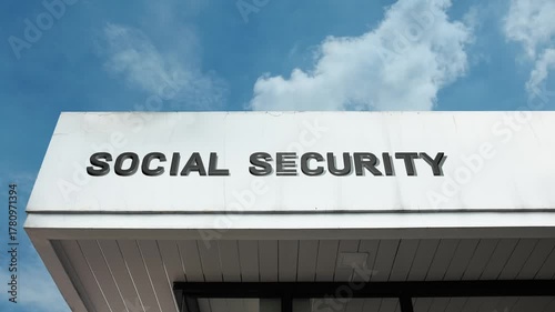 Social Security word sign displayed on a governmental or civic building under a clear blue sky, symbolizing public welfare, retirement, government aid, administration, and public services