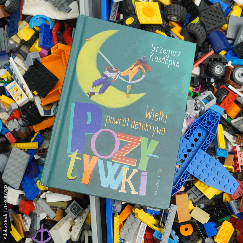 Fototapeta premium Children's book 'Pozytywki' on a colorful background of toy blocks