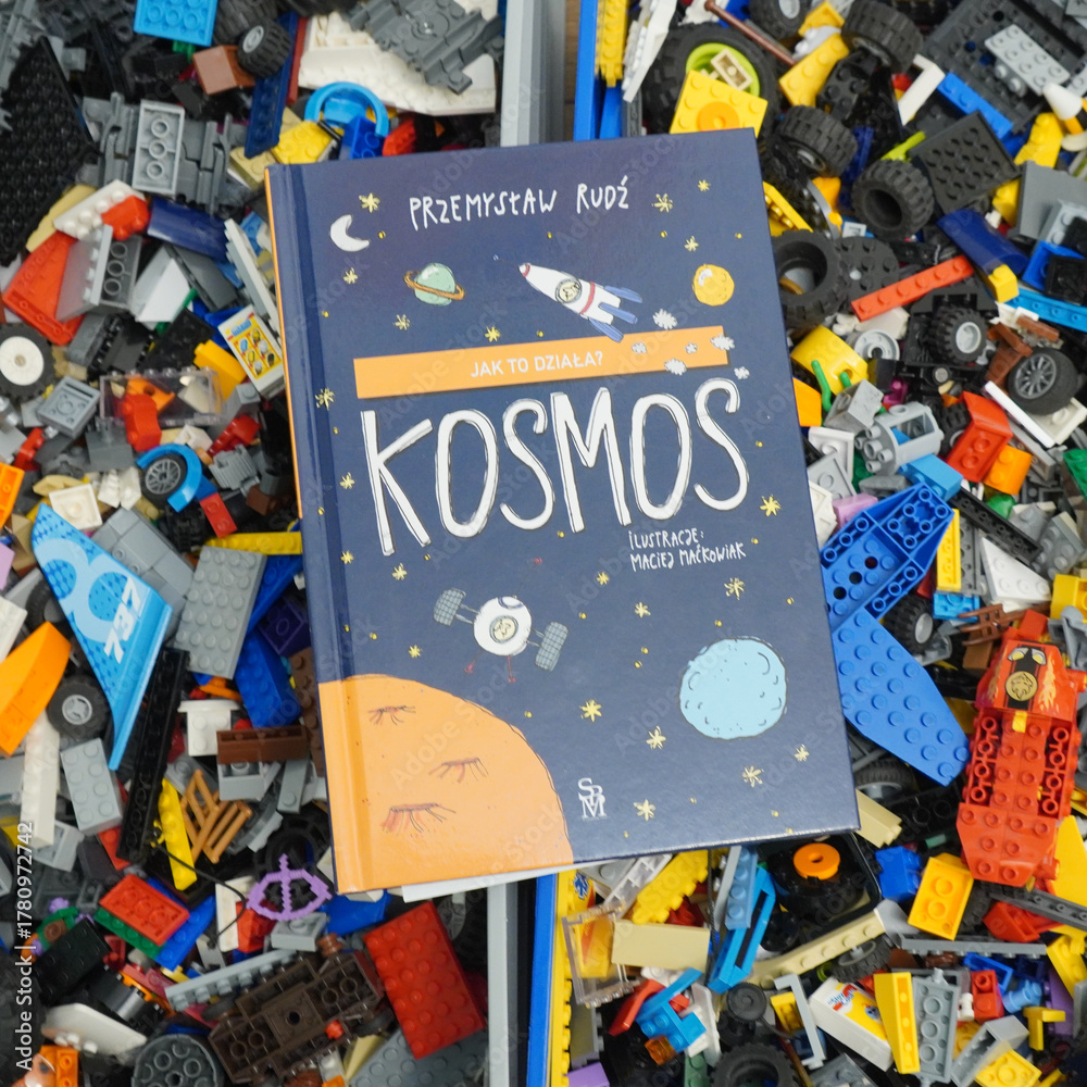 Fototapeta premium A colorful book about space on a background of toy building blocks