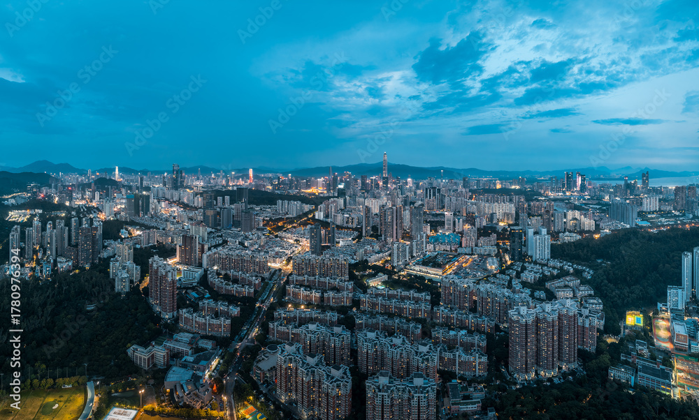 Obraz premium Panoramic view of the illuminated city skyline and sprawling urban landscape at night in Shenzhen, China.