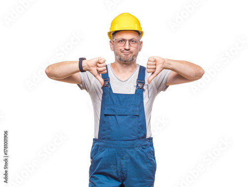 Displeased repairman showing thumbs down, isolated on white background. Dislike or negative concept. Craftsman against white wall