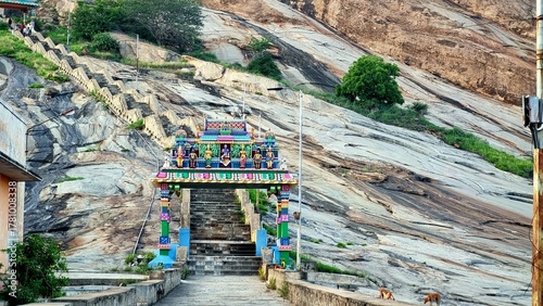Colorful kasi viswanathar temple entrance and stone steps leading up Thiruparankundram Hill in Madurai, Tamil Nadu, showcasing the natural rock landscape and peaceful spiritual atmosphere