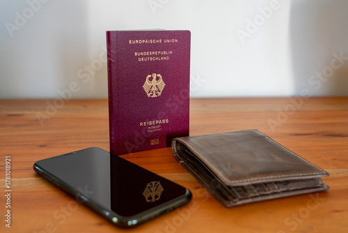 Neuer Deutscher Reisepass, Pass, Ausweis Deutschland - wichtiges Dokument für Urlaub und Einreise im Ausland - mit Geldbeutel und Handy