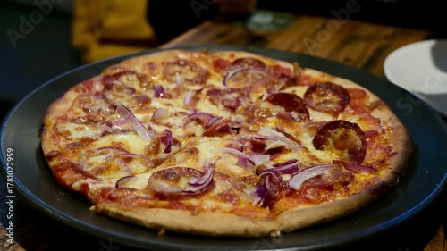 Wallpaper Mural Close-up of a rustic pepperoni and red onion pizza served on a black plate at a contemporary restaurant. Perfect for a savory, casual dinner. Torontodigital.ca