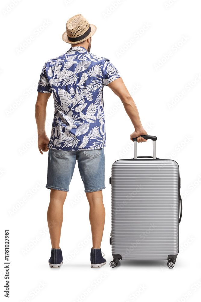 Obraz premium Rear view shot of a man standing with a suitcase