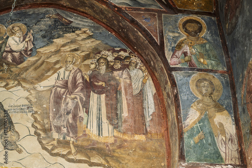 vaulted ceilings and walls covered in religious frescoes and iconography, featuring gold accents, halos, stylized faces in the Monastery of Saint John the Theologian of Patmos, Greece.