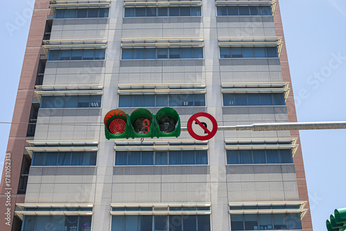 Traffic lights showing red signals with buildings in background.