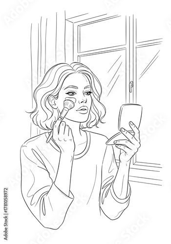 Young woman applying makeup while looking in a mirror indoors  