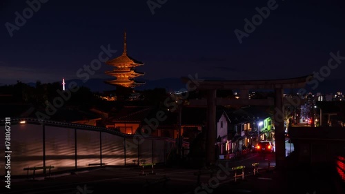 night time lapse view of street with some traffic and torii gate with ancient Yasaka pagoda building at higashiyama in background among Kyoto old town city,famous landmark building in Kyoto japan