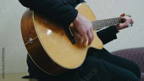 closeup of musician performing gentle melodies on acoustic guitar in comfortable atmosphere