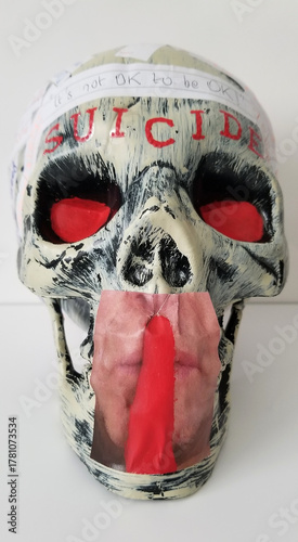 A human skull with glowering red eyes and emblazoned with red letters above the brow spelling the word 