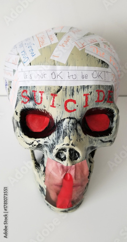 A human skull with glowering red eyes and emblazoned with red letters above the brow spelling the word 