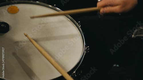 detailed shot of percussionist executing precise stick hits during warmup session in subdued