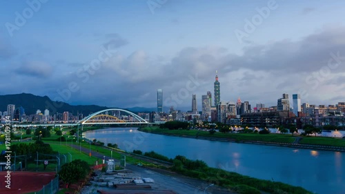 timelapse horizontal landscape view of the Taipei capital city of the Taiwan with highrise skyscraper building under sunset twillight sky time with windy cloudy weather.modern metropolis big city