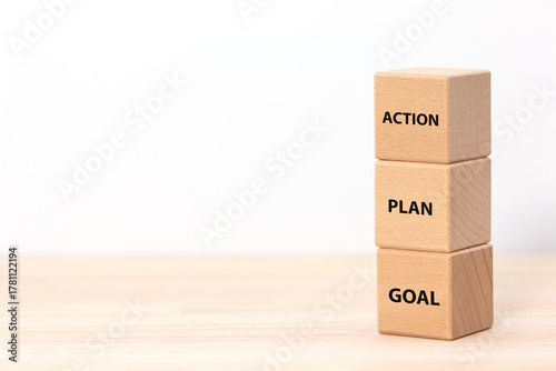 Three wooden cubes stacked vertically with the words GOAL, PLAN, and ACTION. Concept of business strategy, planning process, and steps to achieve success