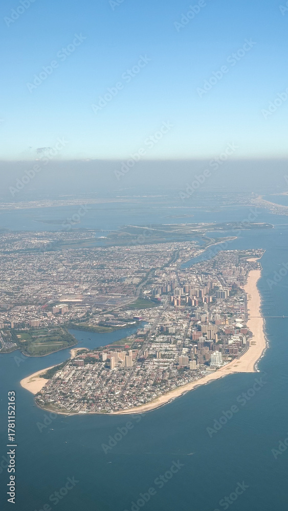 Naklejka premium Aerial view of coastal cityscape with beaches and ocean horizon concept of travel agency, tourism board, real estate firm