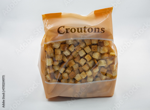 Bag of crunchy croutons closeup on white background.
