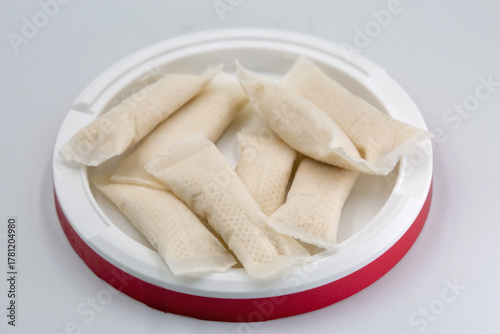 Nicotine pouches red container closeup on white.