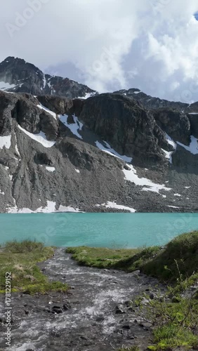 Turquoise Waters of Wedgemount Lake in Whistler with Snow-Capped Mountains and Rushing Stream in BC, Canada