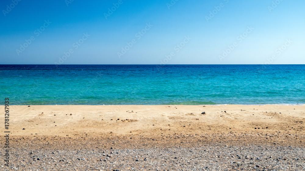 Obraz premium Mazida Ammos Beach, Crete, Greece, with turquoise sea, golden sand and clear blue sky in summer landscape showing Mediterranean coast and calm water