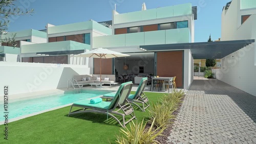 Luxurious villa showcasing a private swimming pool, sun loungers, patio furniture, and an open plan living area, creating a perfect setting for relaxation and entertainment