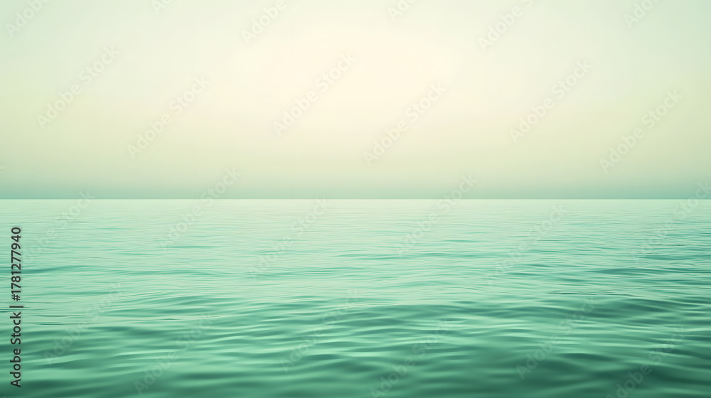 Fototapeta premium A tranquil view of the ocean with gentle waves under a softly lit, pale sky, showcasing a serene natural landscape.