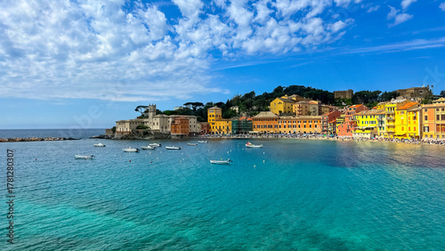 A vibrant seaside view of Sestri Levante Bay, framed by colorful coastal houses and still turquoise water.