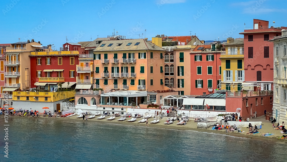 Obraz premium Coastal Charm: Colorful buildings line the shoreline, facing the calm sea under the clear, sunny sky, reflecting the beautiful architecture of the area.