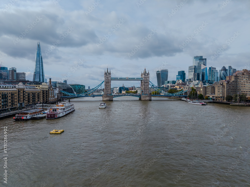 Obraz premium Stunning aerial view of Tower Bridge in London, spanning the River Thames with the city skyline in the background — blending historic architecture and modern urban beauty. London Bridge