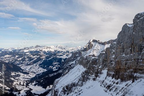 Winter Landscape of Snow-Covered Rocky Mountains and Scenic Alpine Valley in Switzerland.