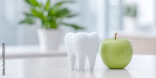 White apple and a white tooth are on a table
