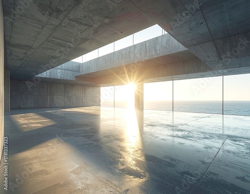 Vast concrete interior with floor-to-ceiling windows and ocean sunrise