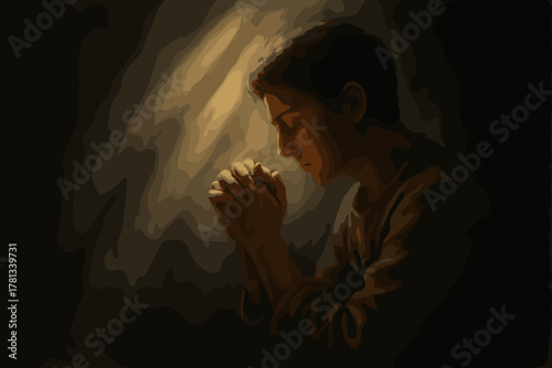Young male with short hair praying quietly in a dimly lit space, with hands clasped and eyes closed, expressing contemplation and solemnity.